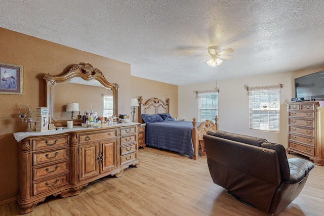 bedroom with ceiling fan, a textured ceiling, and light hardwood / wood-style flooring