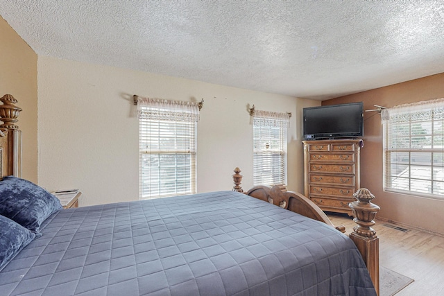 bedroom with wood-type flooring and a textured ceiling