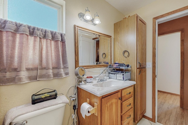 bathroom with vanity, wood-type flooring, and toilet