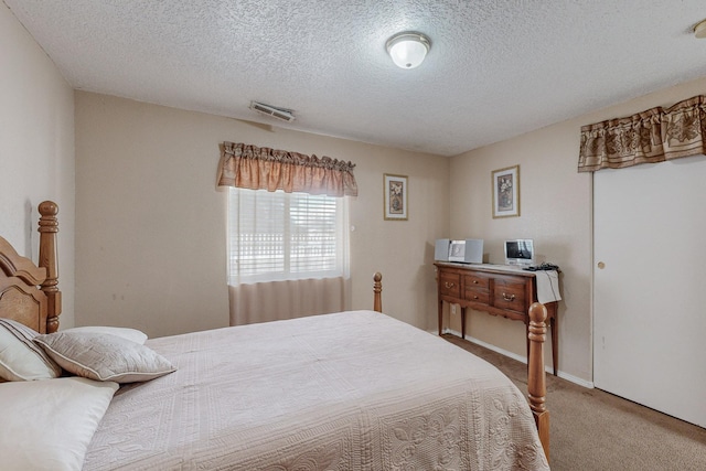 bedroom featuring carpet and a textured ceiling