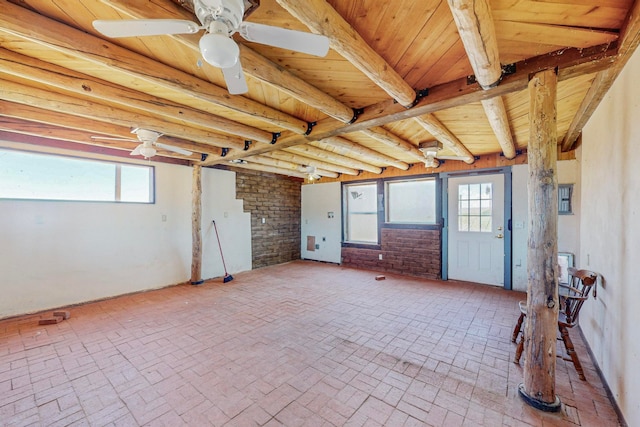 interior space featuring brick wall, wooden ceiling, and ceiling fan