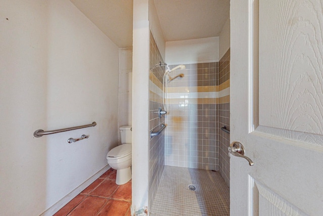 bathroom with tile patterned floors, tiled shower, and toilet