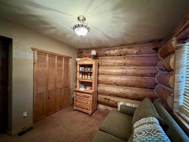 interior space with rustic walls, visible vents, light carpet, a textured ceiling, and baseboards