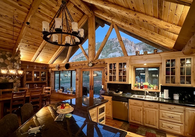 kitchen with dark countertops, a sink, a notable chandelier, and stainless steel dishwasher