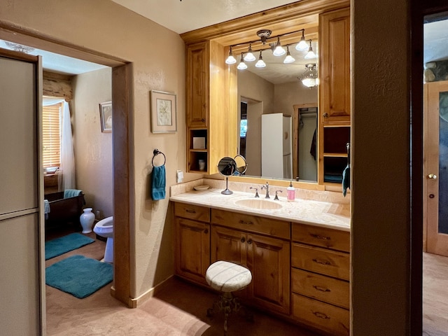 bathroom with a bidet, a textured wall, vanity, and baseboards