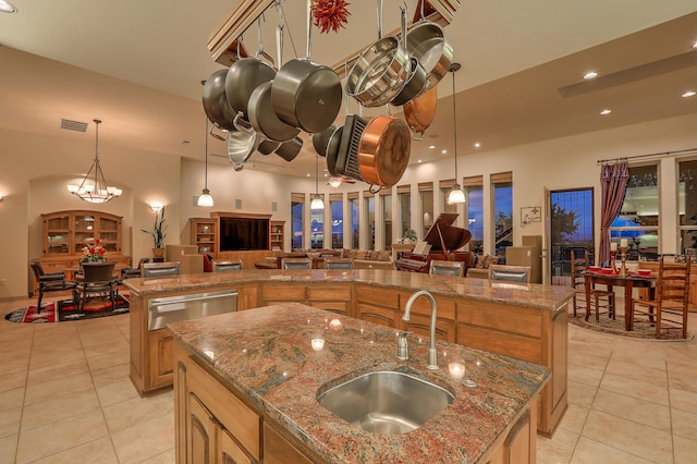 kitchen featuring a large island with sink, sink, pendant lighting, and light tile patterned floors