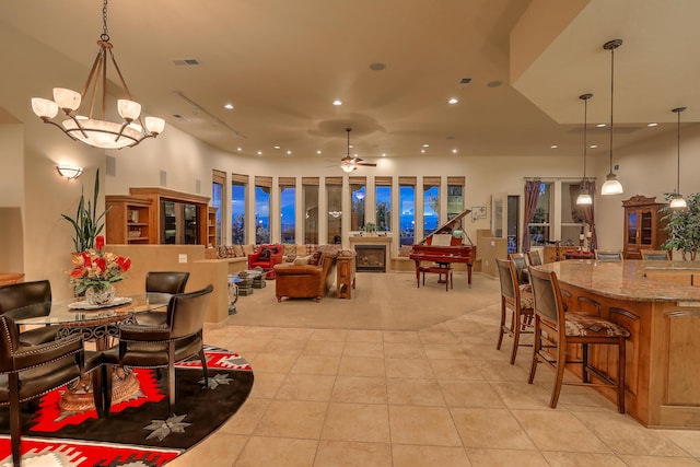 tiled dining area with ceiling fan with notable chandelier