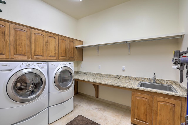 laundry room with sink, cabinets, washing machine and clothes dryer, and light tile patterned flooring