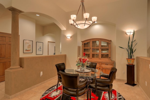 tiled dining room with decorative columns and an inviting chandelier