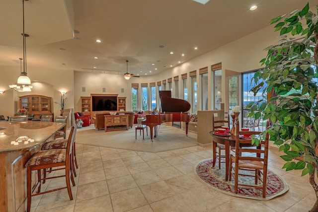 tiled dining room featuring ceiling fan with notable chandelier