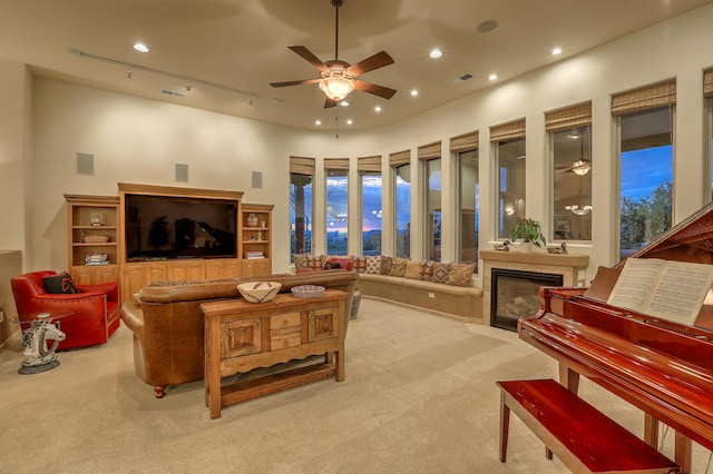 carpeted living room featuring rail lighting and ceiling fan