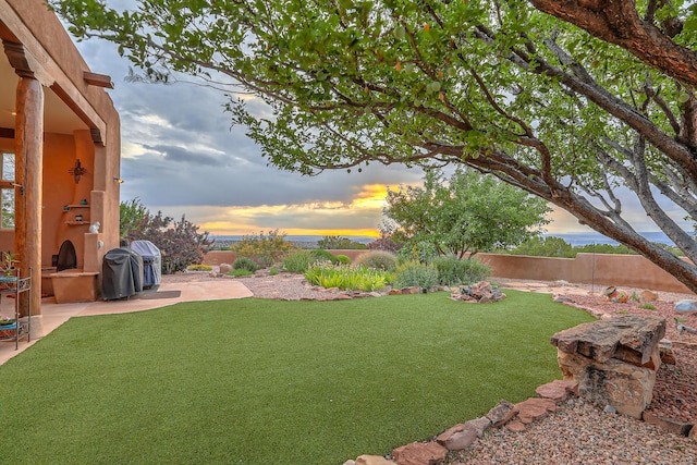 yard at dusk with a patio area