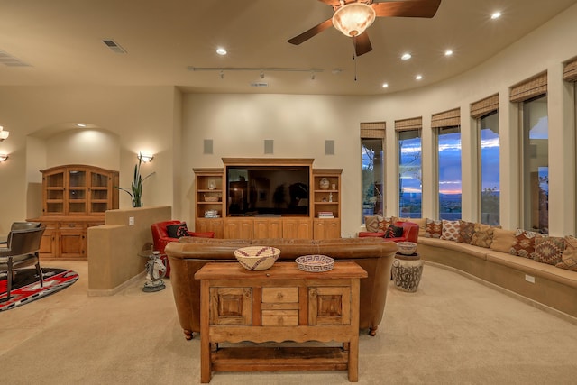 carpeted living room with ceiling fan and rail lighting