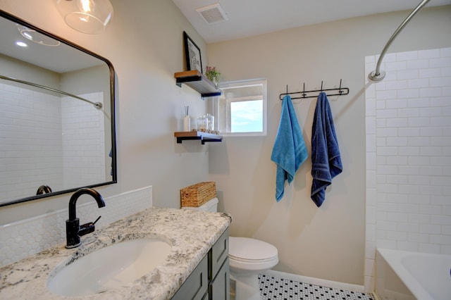 full bathroom featuring vanity, tiled shower / bath, tile patterned flooring, and toilet