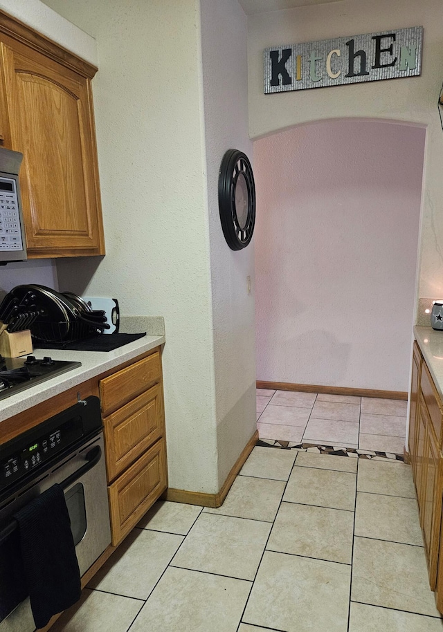 kitchen with light tile patterned floors and black appliances