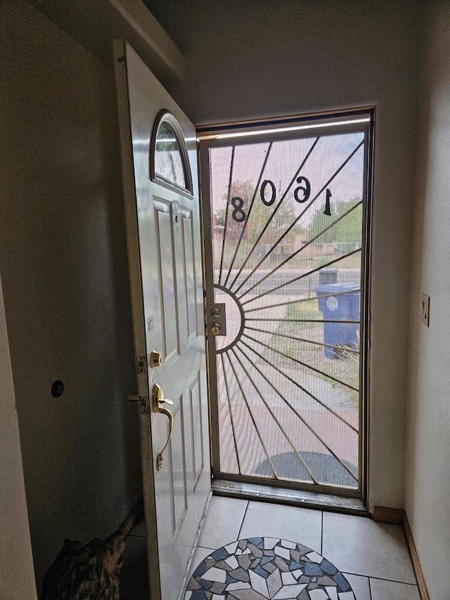 doorway to outside with light tile patterned floors