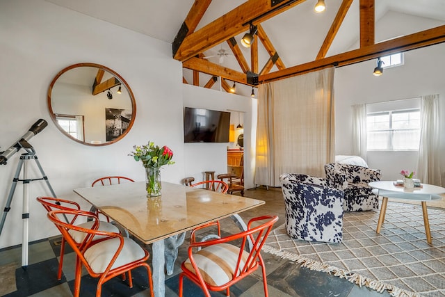 dining space with high vaulted ceiling and beam ceiling