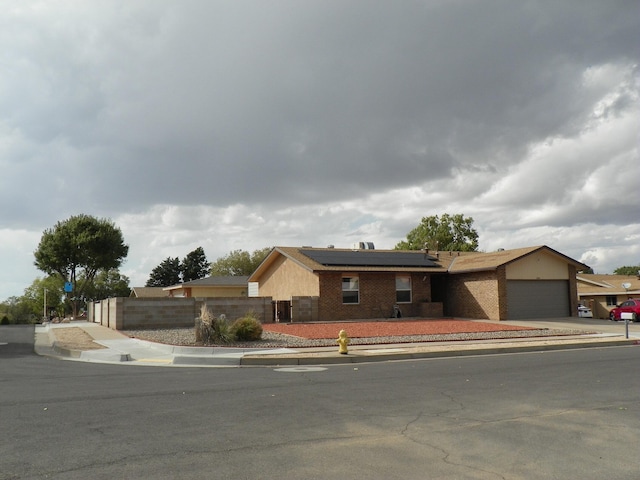 single story home with solar panels and a garage