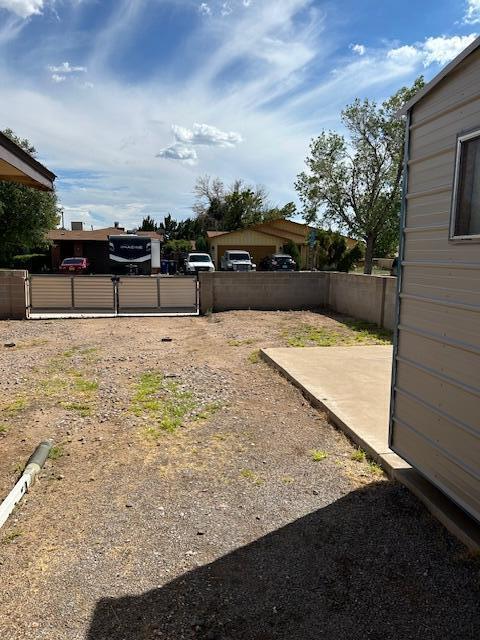view of yard with a patio area, fence, and a gate