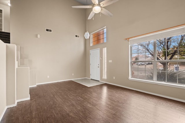 entrance foyer with hardwood / wood-style floors, ceiling fan, and a towering ceiling