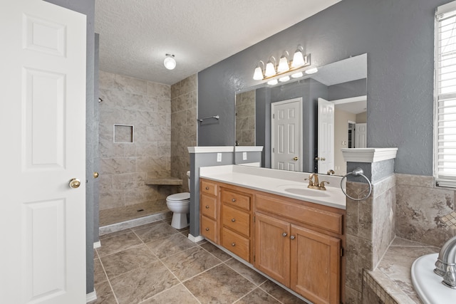 full bathroom featuring tile patterned floors, vanity, a textured ceiling, independent shower and bath, and toilet