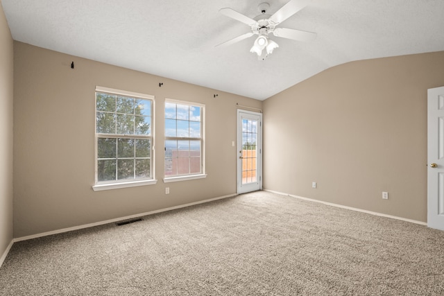 carpeted spare room featuring ceiling fan, a textured ceiling, and vaulted ceiling