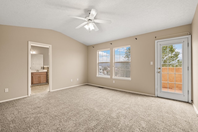 interior space with a wealth of natural light, ceiling fan, vaulted ceiling, and light colored carpet