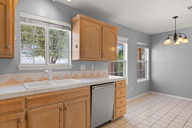 kitchen featuring dishwasher, tile counters, sink, and a chandelier