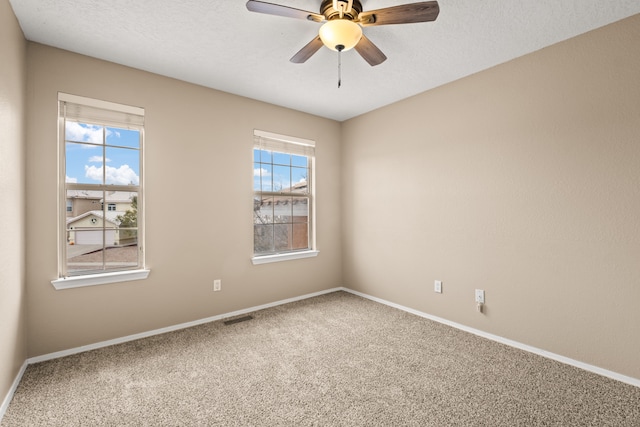 empty room featuring ceiling fan, a textured ceiling, and carpet flooring