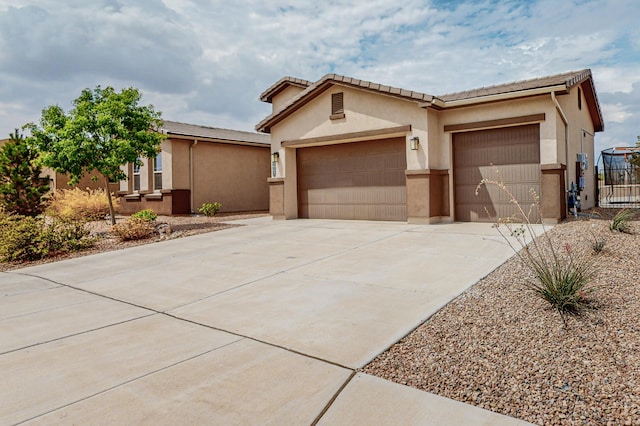 view of front of property featuring a garage, fence, a tile roof, concrete driveway, and stucco siding