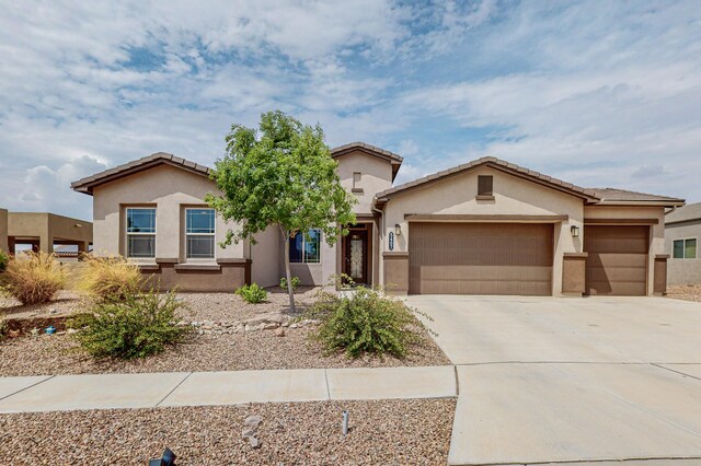 view of front facade with a garage, concrete driveway, and stucco siding