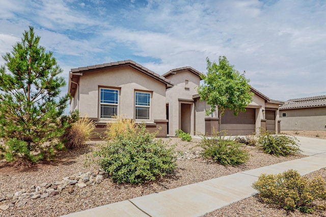 view of front of home with a garage, concrete driveway, and stucco siding