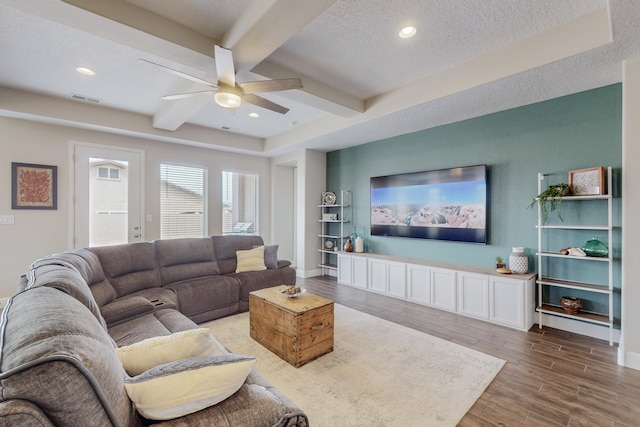 living area featuring beam ceiling, recessed lighting, visible vents, a textured ceiling, and wood finished floors