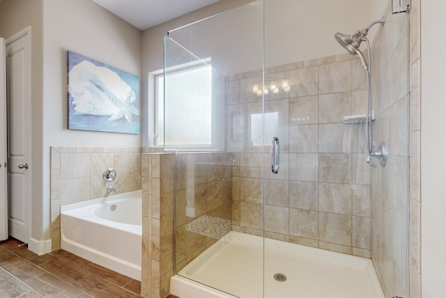 full bath featuring a garden tub, wood finish floors, and a shower stall