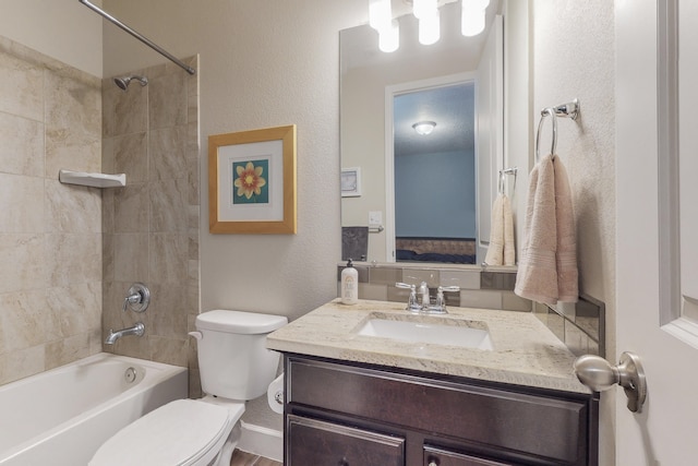 full bathroom featuring toilet, a textured wall, shower / washtub combination, and vanity