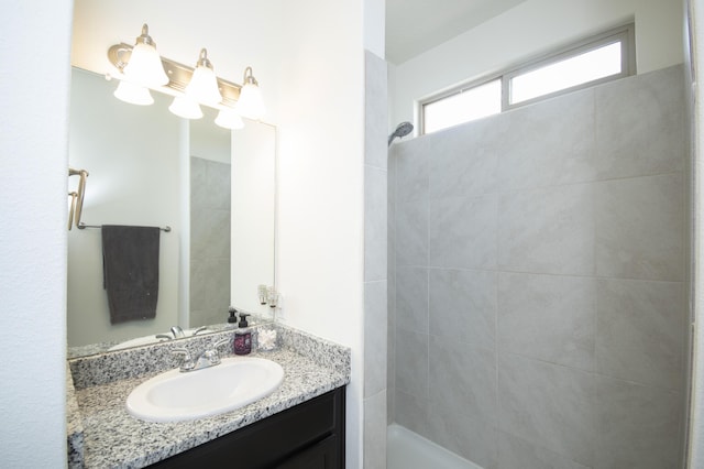 bathroom with vanity and tiled shower