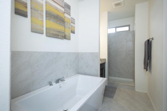 bathroom featuring tile patterned flooring, vanity, and plus walk in shower