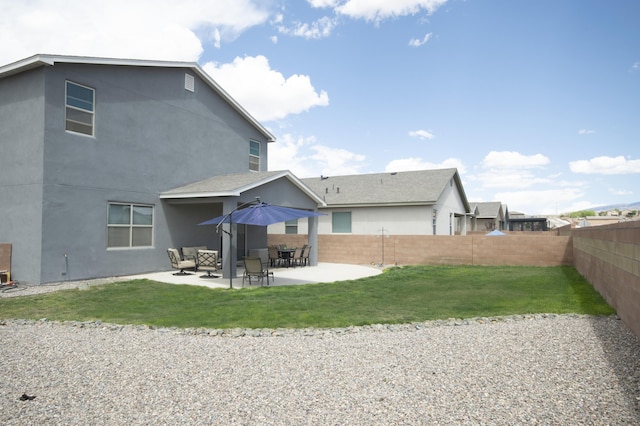 back of property featuring a lawn and a patio area