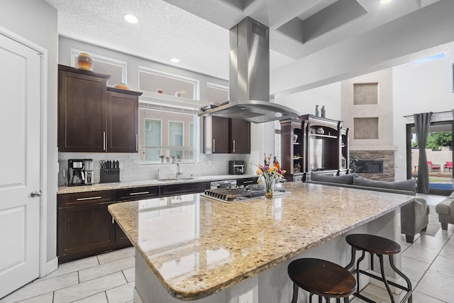 kitchen with a textured ceiling, a center island, and island exhaust hood