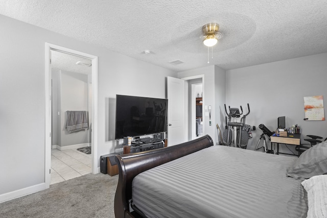 carpeted bedroom with ceiling fan and a textured ceiling