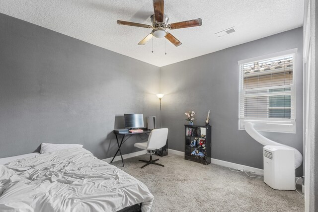 carpeted bedroom with ceiling fan and a textured ceiling