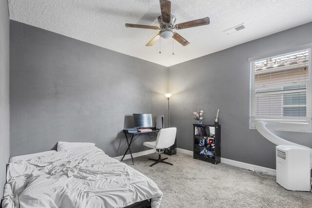 bedroom featuring light carpet, a textured ceiling, and ceiling fan