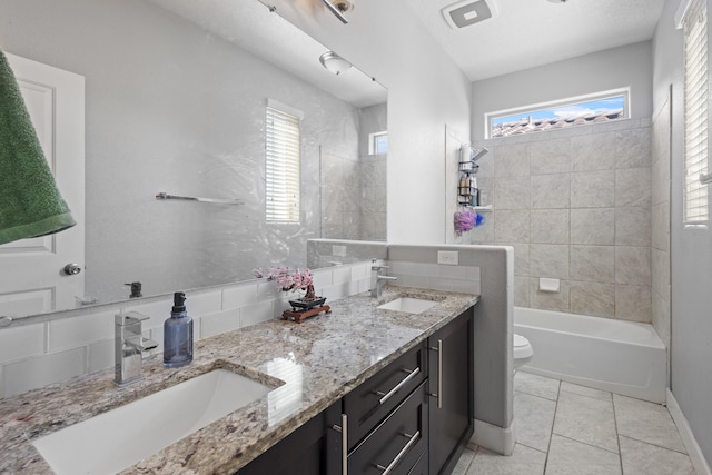 full bathroom with tile patterned floors, vanity, toilet, and tiled shower / bath