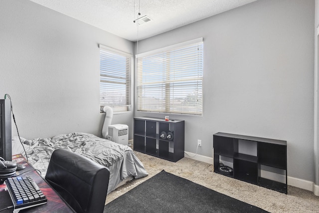 bedroom featuring multiple windows, carpet floors, and a textured ceiling