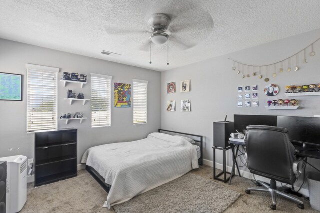 carpeted bedroom with a textured ceiling and ceiling fan