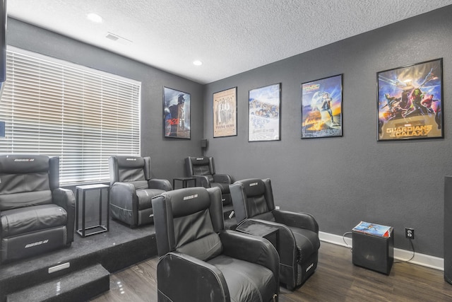 home theater room featuring wood-type flooring and a textured ceiling