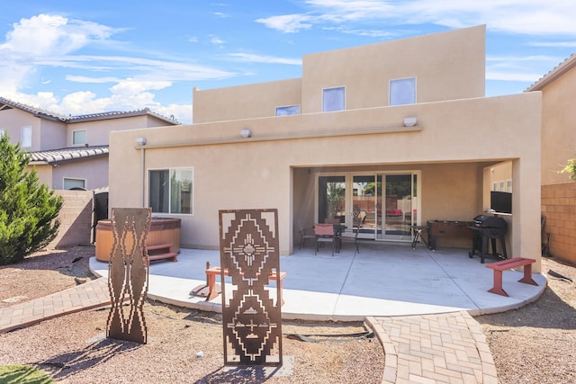 back of house with a patio and a hot tub