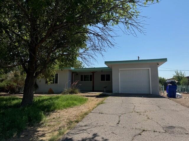 ranch-style house featuring a garage, aphalt driveway, and stucco siding