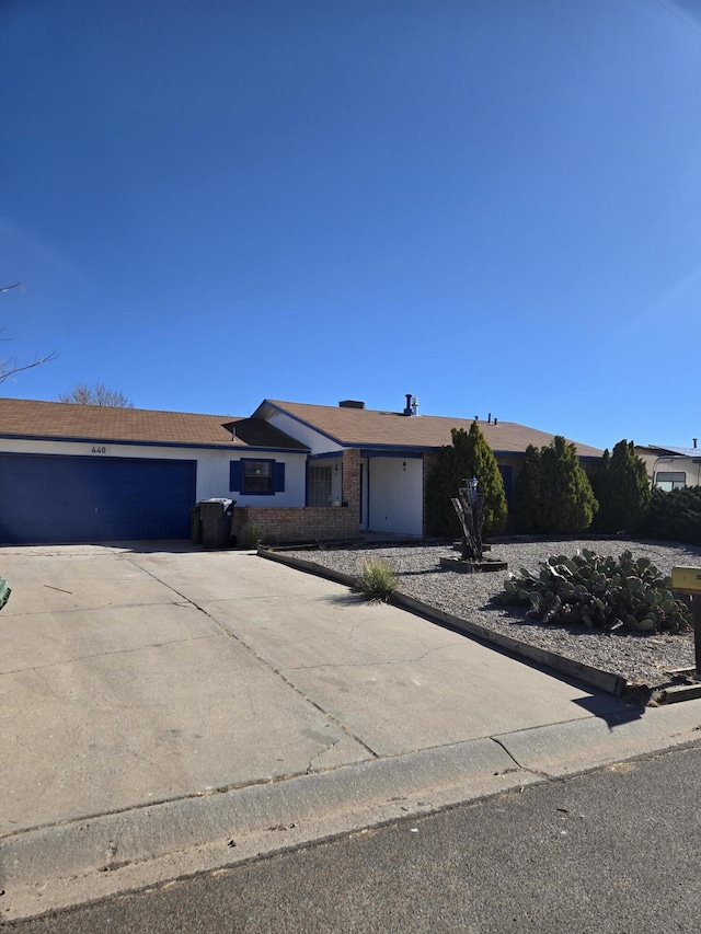 ranch-style house with a garage, driveway, and brick siding