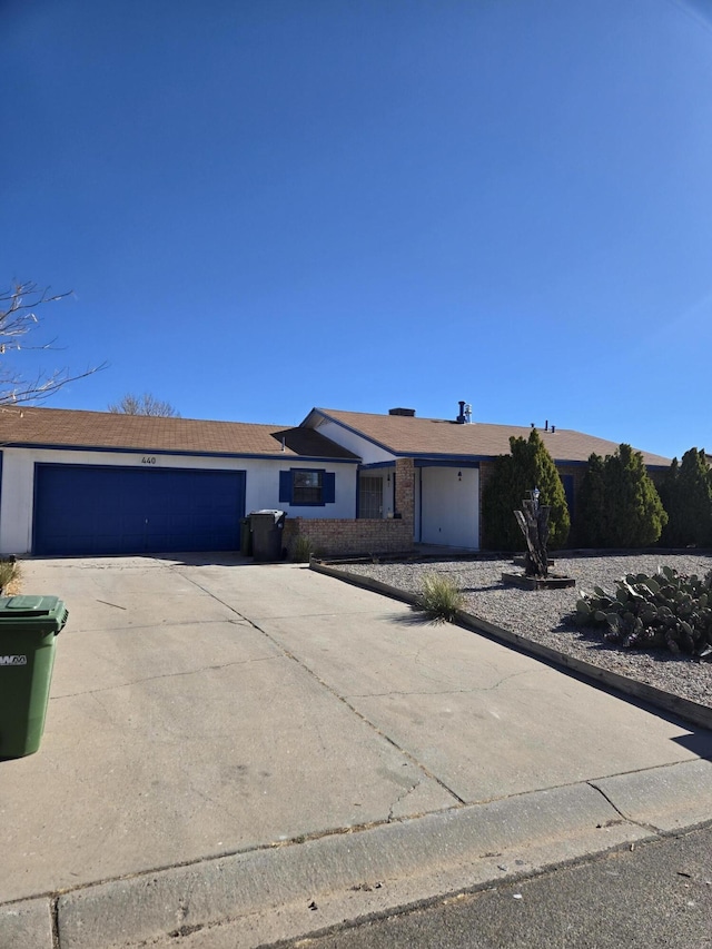 ranch-style home featuring an attached garage and driveway